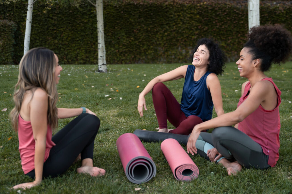 Some Ladies sat around on the grass after a yoga class